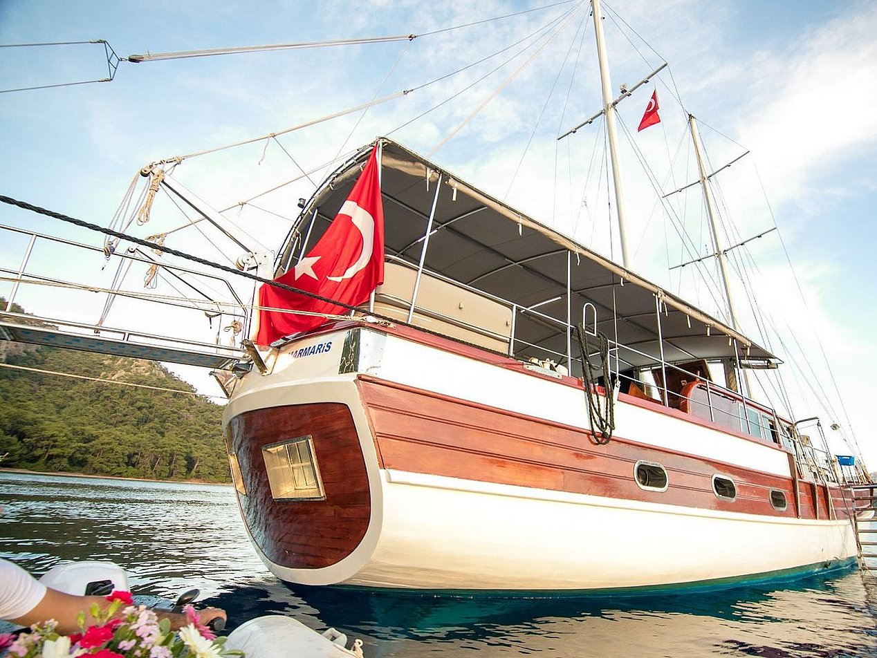 Denizde, Türk bayrağı asılı ahşap ve beyaz renkli yelkenli tekne.